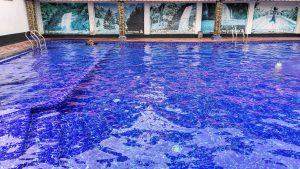 A large, clear blue swimming pool with tile steps. 